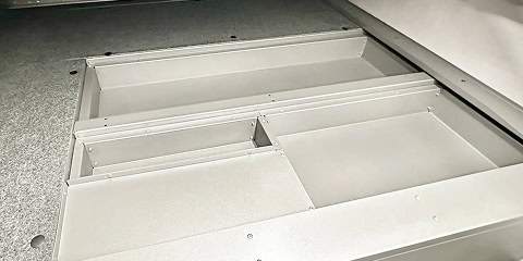 Arkto Campers outdoor kitchen setup under awning beside mountain lake